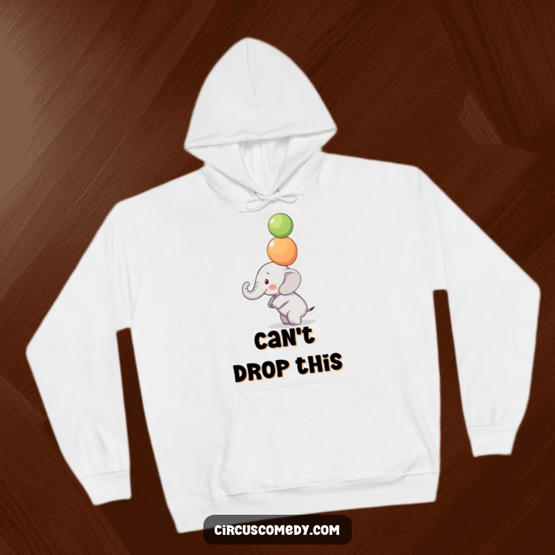 Funny Focused Elephant Hoodie: A small elephant balances colorful balls on its trunk with intense focus, a cozy and funny apparel.