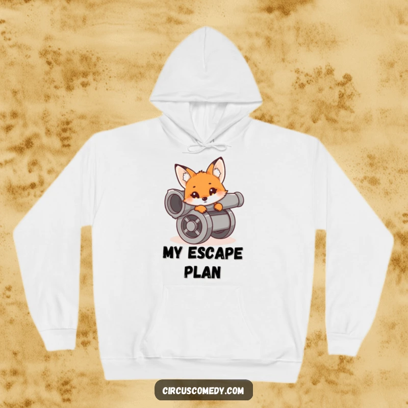 A curious fox peeking out from inside a cannon, looking ready for adventure, presented on a soft and warm hoodie.