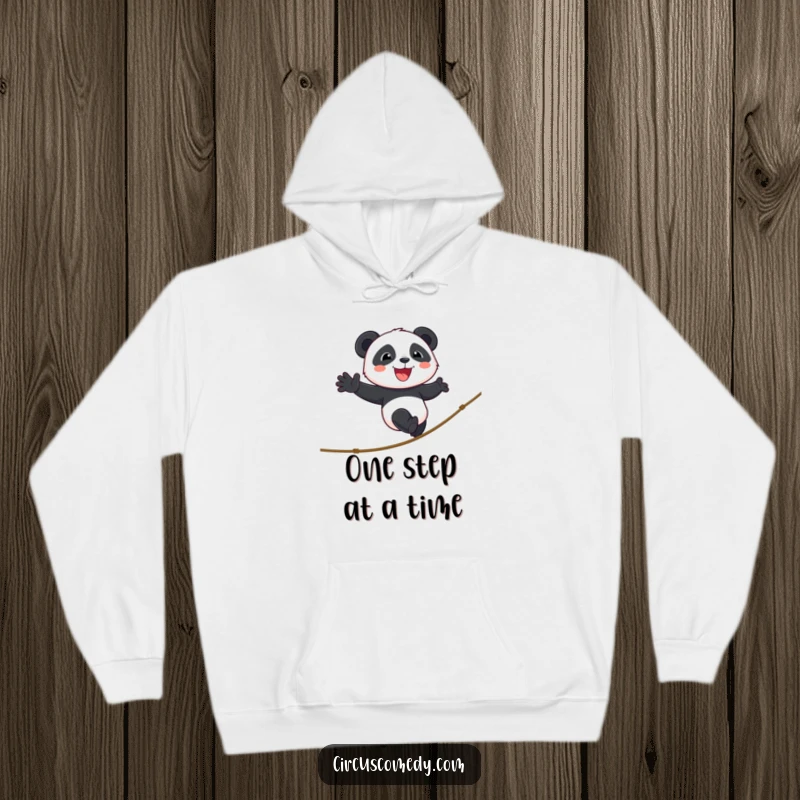 Funny panda hoodie featuring a smiling panda walking a tightrope with cheerful determination, offering warmth and whimsical inspiration.